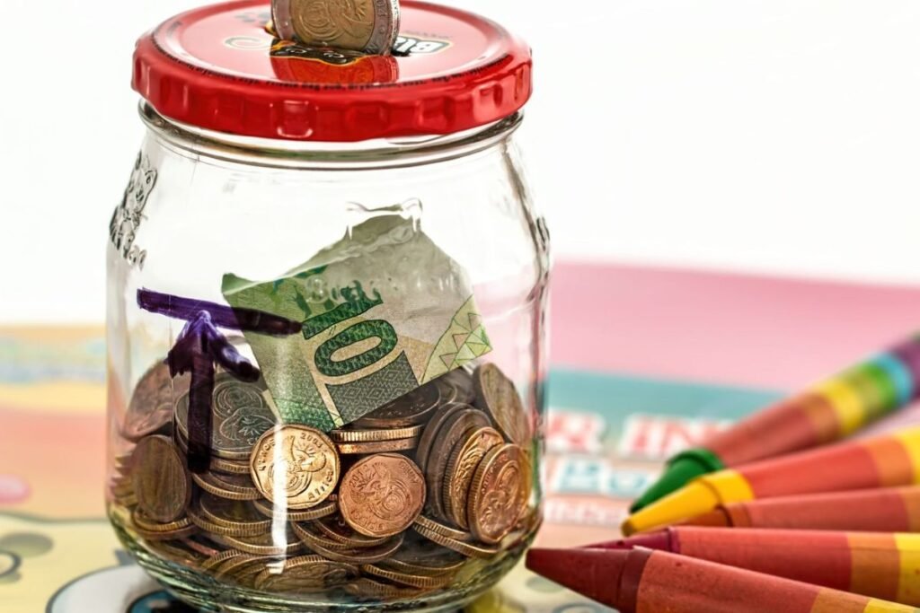 GlassPersonal finance tips for beginners featuring budgeting, saving, investing, and wealth-building concepts savings jar with cash and coins illustrating how to build wealth with $100 a month